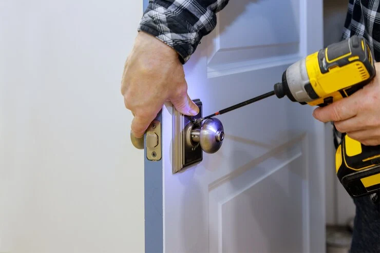 Låsesmed med skrutrekker monterer dør til adgangsrom ny lås i huset